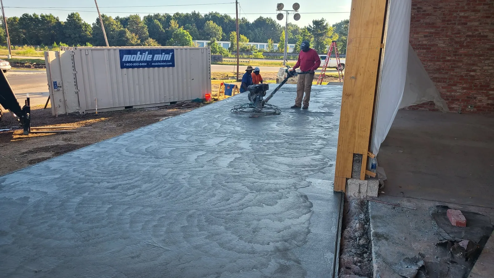 Pouring and finishing new concrete outside the building.