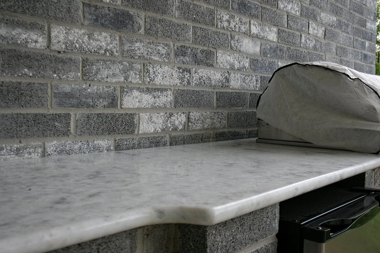 Close-up of a marble-look countertop edge on the outdoor kitchen.