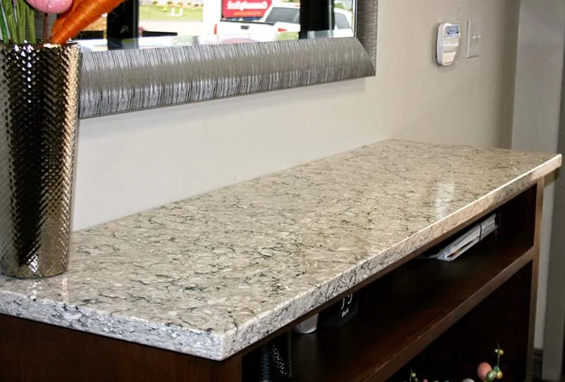 Speckled quartz countertop on a dark wood counter.