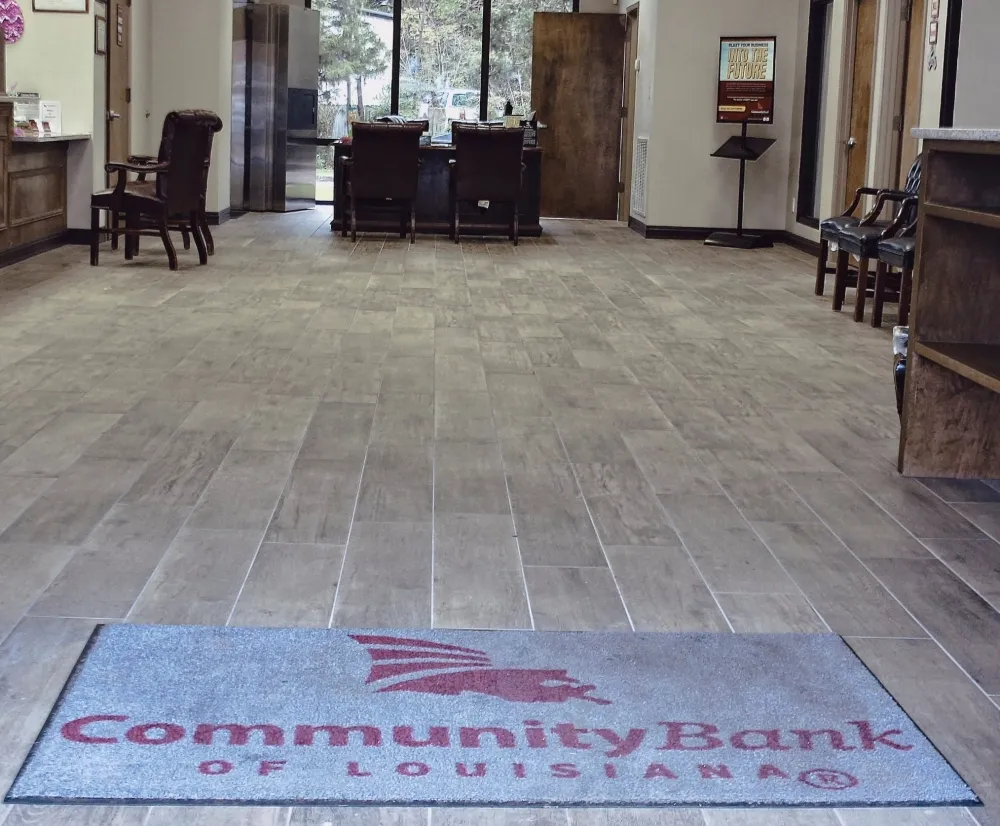 Bank entrance with wood-look tile floors and a Community Bank entry mat.