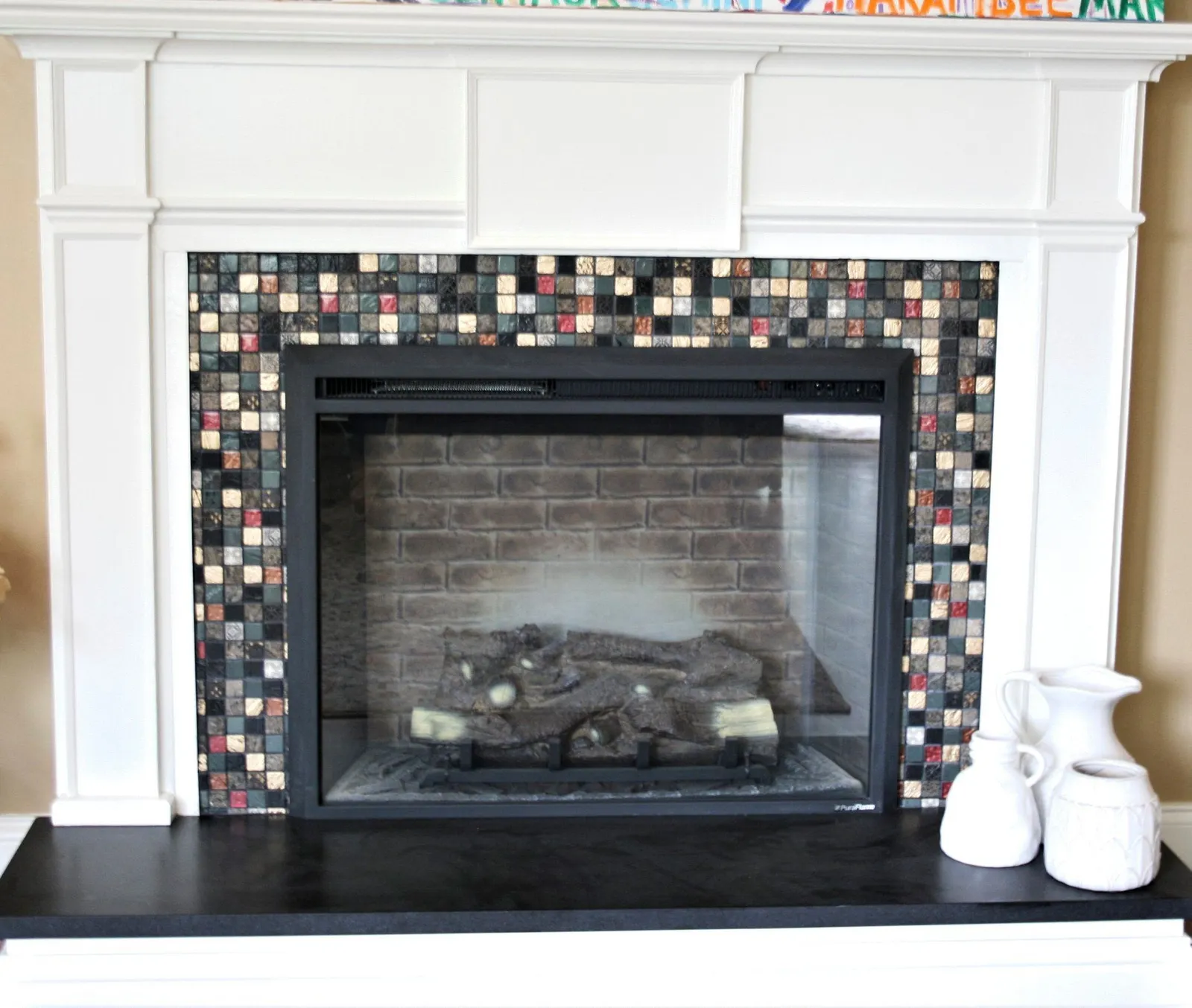 Fireplace surround in colorful glass mosaic tile under a white mantel.