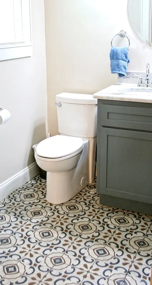 Half bath with a patterned black-and-white floor tile and a gray vanity.