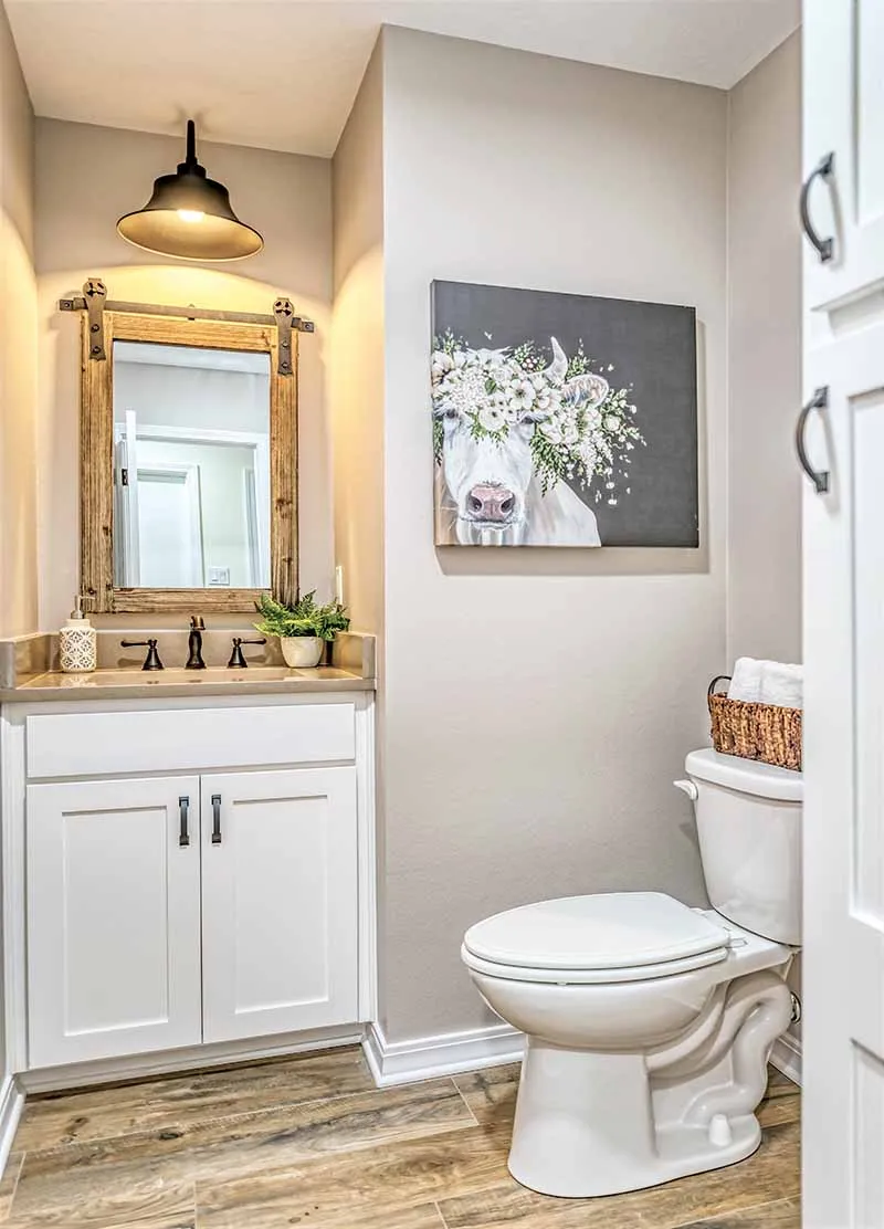 Half bathroom with a white vanity and wood-look tile floor.