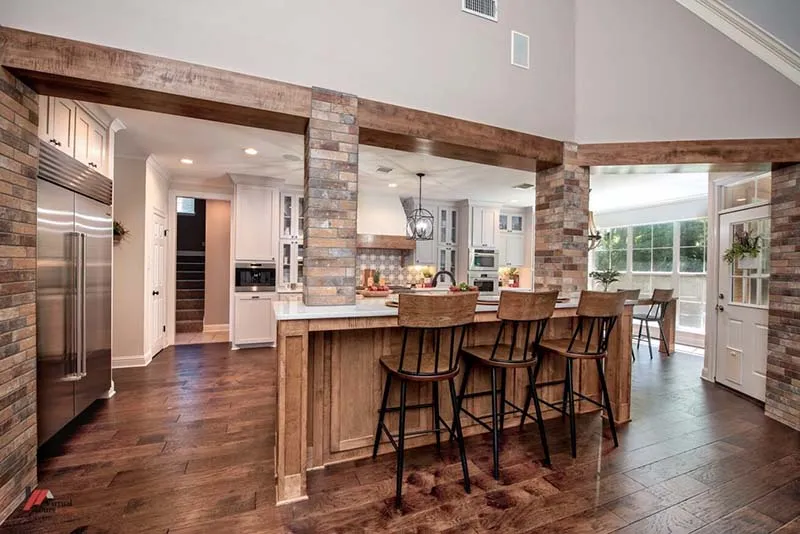 Brick-look tile columns and beams framing the kitchen and bar seating.