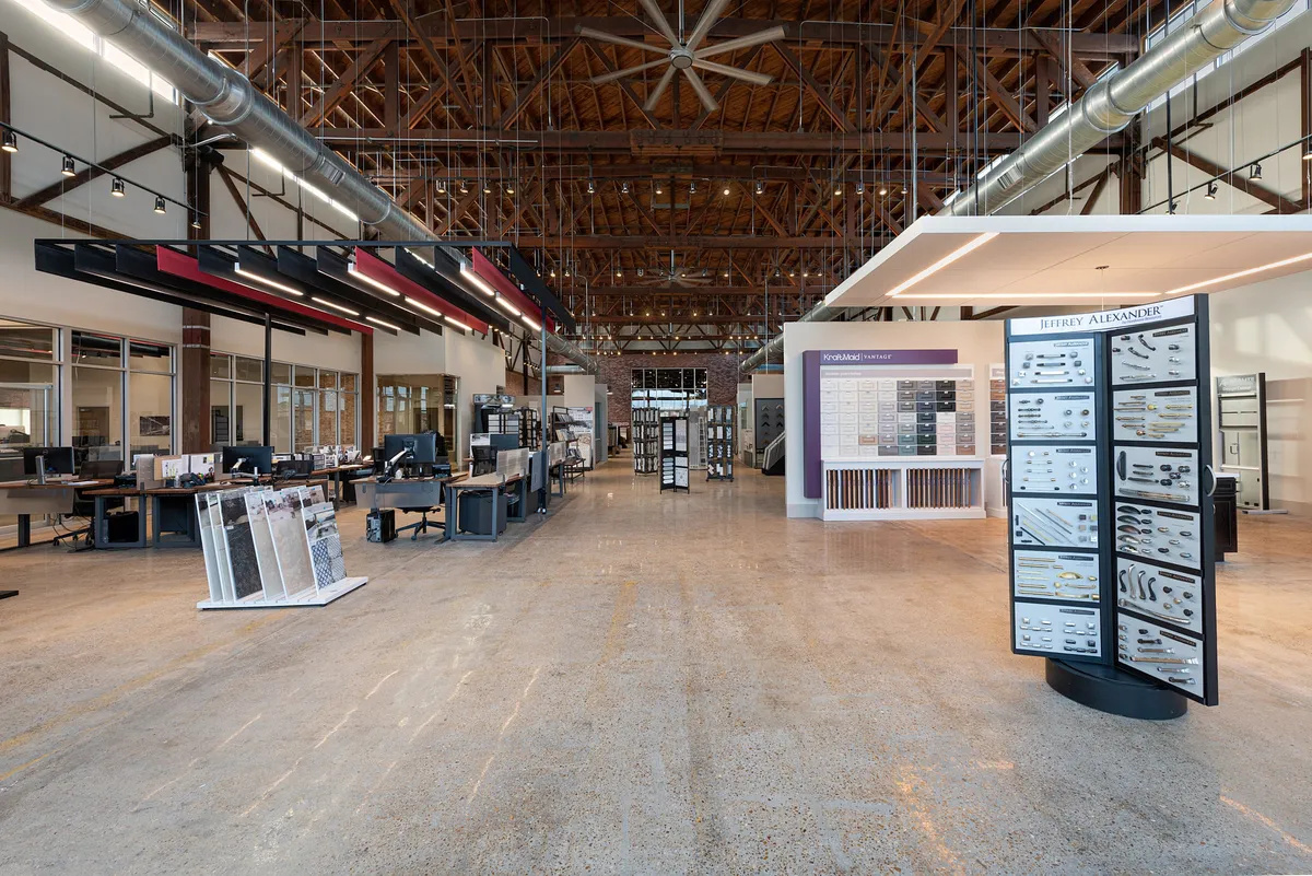 The United Tile showroom floor, with tile and stone sample displays under a high warehouse ceiling.