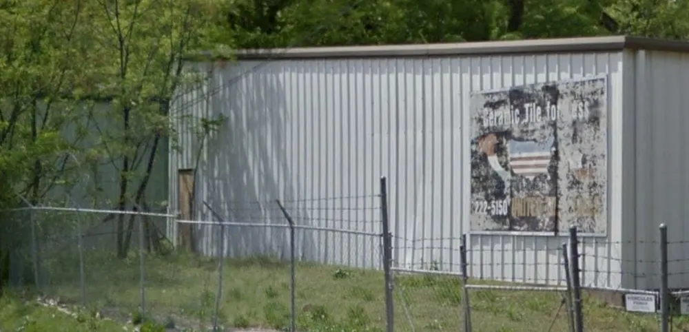 Weathered “Ceramic Tile for Less” sign with the United Tile phone number on a metal building on Levy Street.